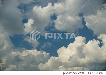 Blue Sky With Fluffy White Cumulus Clouds Overhead On A Bright Summer Day Blue Sky With Fluffy White Cumulus Clouds Overhead On A Bright Summer Day 137320392