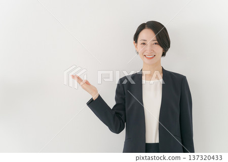 一位女士穿著西裝來展示 137320433