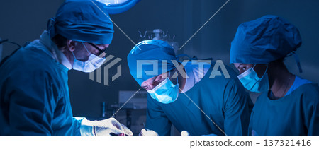 Group of concentrated surgical doctor team doing surgery patients in hospital operating theater. Professional medical team doing critical operations. Group of concentrated surgical doctor team doing surgery patients in hospital operating theater. Professional medical team doing critical operations. 137321416