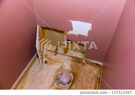 Wall is cut open exposing pipes plumbing for bathroom repair taking place in home. Wall is cut open exposing pipes plumbing for bathroom repair taking place in home. 137321567