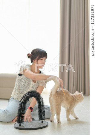 Relaxed asian woman gently petting friendly domestic cat at home promoting mental health wellness and positive emotional animal care bonding with furry feline pet sitting on floor Relaxed asian woman gently petting friendly domestic cat at home promoting mental health wellness and positive emotional animal care bonding with furry feline pet sitting on floor 137321973