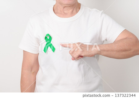 Elderly with Green Ribbon for concept of April Donate Life month, Organ Donation and Transplant Awareness, May Mental Health Awareness month and October Liver cancer. Health and world cancer day Elderly with Green Ribbon for concept of April Donate Life month, Organ Donation and Transplant Awareness, May Mental Health Awareness month and October Liver cancer. Health and world cancer day 137322344