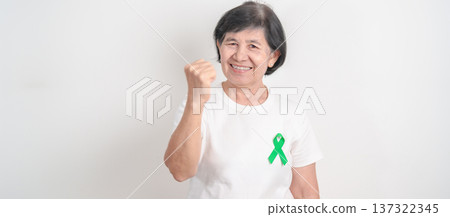 Elderly with Green Ribbon for concept of April Donate Life month, Organ Donation and Transplant Awareness, May Mental Health Awareness month and October Liver cancer. Health and world cancer day Elderly with Green Ribbon for concept of April Donate Life month, Organ Donation and Transplant Awareness, May Mental Health Awareness month and October Liver cancer. Health and world cancer day 137322345