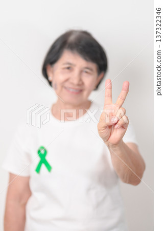 Elderly with Green Ribbon for concept of April Donate Life month, Organ Donation and Transplant Awareness, May Mental Health Awareness month and October Liver cancer. Health and world cancer day Elderly with Green Ribbon for concept of April Donate Life month, Organ Donation and Transplant Awareness, May Mental Health Awareness month and October Liver cancer. Health and world cancer day 137322346