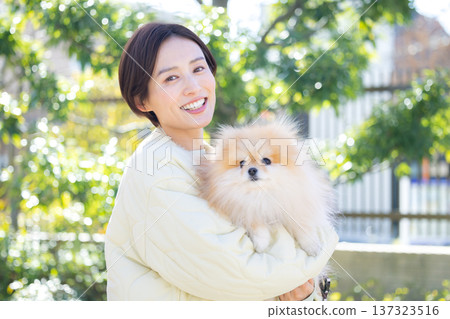 Lifestyle: A woman holding her pet dog Lifestyle: A woman holding her pet dog 137323516
