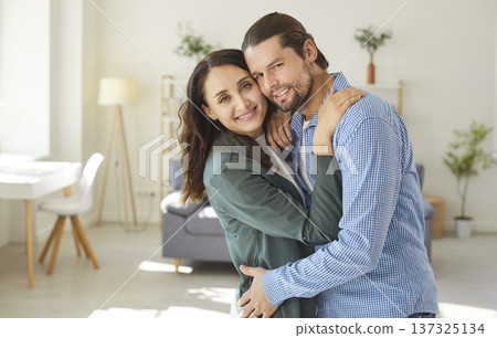Loving couple in close hug, family celebrate relocation to new modern apartment, husband and wife 137325134