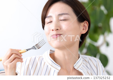 一位女士正在津津有味地享用美食 137325232