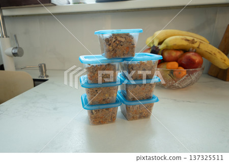 Stacked containers hold breakfast oats on a clean countertop Stacked containers hold breakfast oats on a clean countertop 137325511