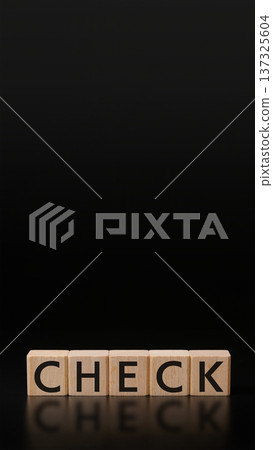 Wooden building blocks "CHECK" letters on a black matte background, vertical composition, copy space Wooden building blocks "CHECK" letters on a black matte background, vertical composition, copy space 137325604