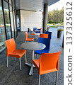 Orange and Blue Chairs and Round Tables in Street Cafe. 137325612