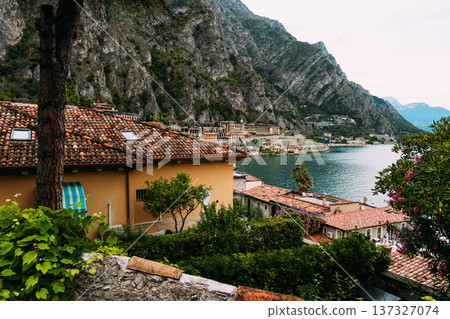 Scenic view of Limone sul Garda with houses, mountains, and the lake. Scenic view of Limone sul Garda with houses, mountains, and the lake. 137327074