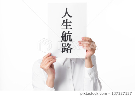 一個穿著白襯衫的人雙手拿著一張紙，上面寫著「人生之路」。 137327137