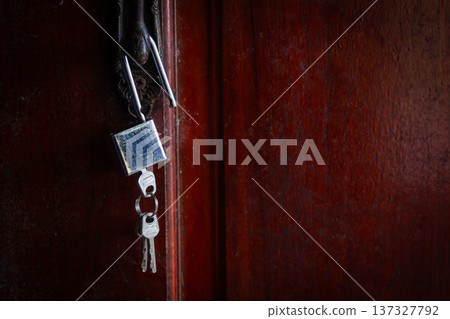 House key left hanging on an empty door symbolizes abandonment, separation, loneliness, and emotional loss. 137327792