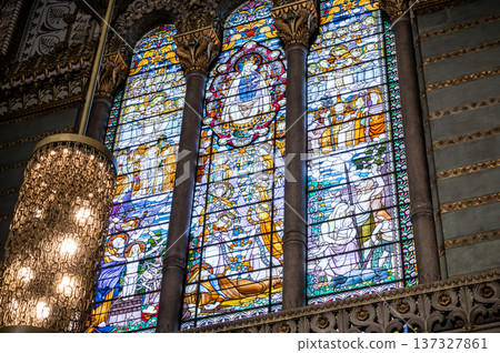 Lyon, france. December 27,2023. Our lady of fourviere basilica stained glass depicting the virgin mary with child amid ornate sacred scenes, colorful light filled panels Lyon, france. December 27,2023. Our lady of fourviere basilica stained glass depicting the virgin mary with child amid ornate sacred scenes, colorful light filled panels 137327861