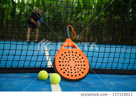 Padel game in a tropical setting with visible gear 137328021
