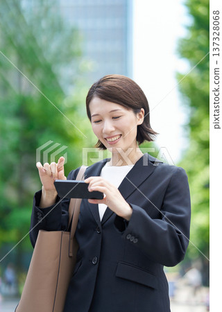Business woman operating a smartphone Business woman operating a smartphone 137328068