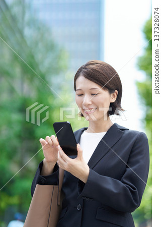 Business woman operating a smartphone Business woman operating a smartphone 137328074