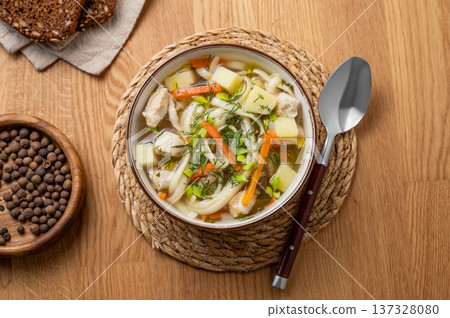 Chicken noodle soup with fresh dill in a bowl on a wooden background Chicken noodle soup with fresh dill in a bowl on a wooden background 137328080