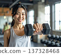 Young woman learning dumbbell exercises from gym trainer 137328468