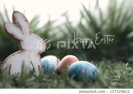 Wooden bunny sits in grass. Colorful eggs lie beside it. Soft focus green grass background. Gentle spring atmosphere. Perfect for Easter themes 137328622