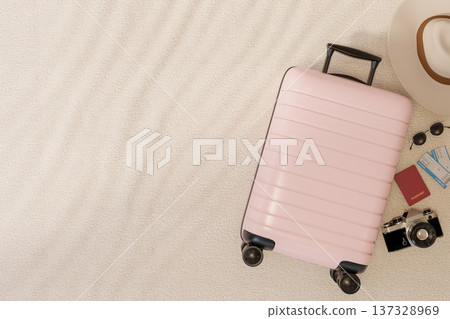 Top view of pink luggage suitcase with camera, hat, passport, boarding pass and sunglasses on floor. Top view of pink luggage suitcase with camera, hat, passport, boarding pass and sunglasses on floor. 137328969