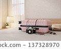 Camera beside pink luggage suitcase with passport and boarding pass aside sunglasses and hat on bed. 137328970