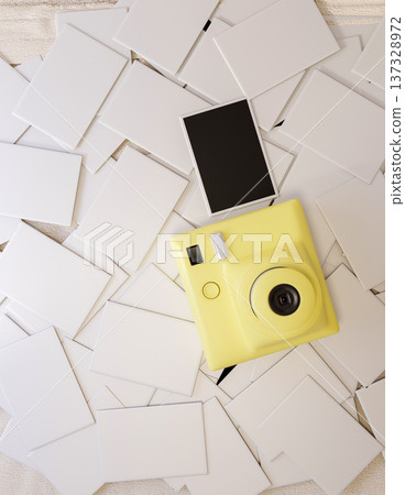 Top view of a yellow instant camera and film photo on the pile of white paper postcard or envelopes. Top view of a yellow instant camera and film photo on the pile of white paper postcard or envelopes. 137328972