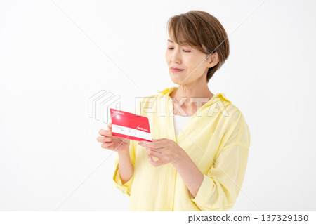 A woman who is worried about looking at her passbook 137329130