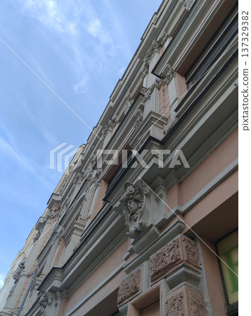 A close-up of a historic building facade with intricate decorative elements, including sculpted reliefs and ornamental columns. The craftsmanship highlights classical architectural elegance. A close-up of a historic building facade with intricate decorative elements, including sculpted reliefs and ornamental columns. The craftsmanship highlights classical architectural elegance. 137329382