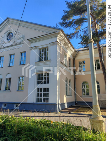A stately building with decorative reliefs and symmetrical windows surrounded by lush plants. The photo captures the harmonious blend of nature and architectural heritage. A stately building with decorative reliefs and symmetrical windows surrounded by lush plants. The photo captures the harmonious blend of nature and architectural heritage. 137329394