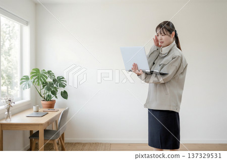 A female worker with a stiff expression looking at the screen A female worker with a stiff expression looking at the screen 137329531