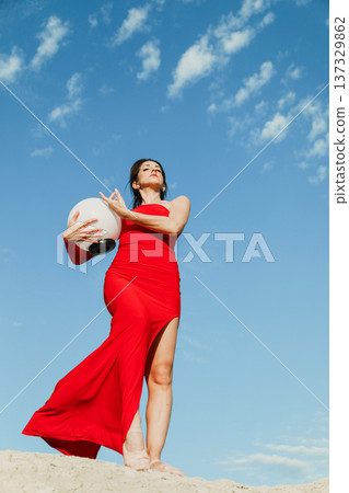 Woman in red dress looking at the blue sky in Calabria region 137329862