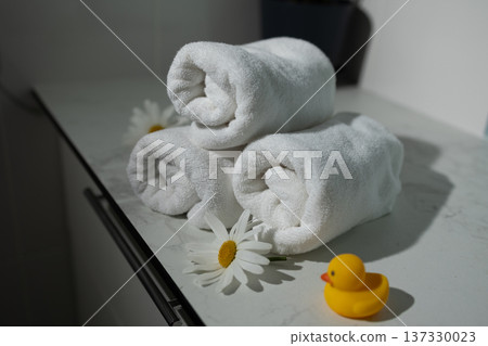 Relaxing Spa Setup With Neatly Rolled Towels and a Charming Rubber Duck 137330023