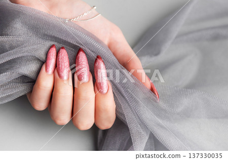 Woman's hand showing stylish textured pink stiletto nails Woman's hand showing stylish textured pink stiletto nails 137330035