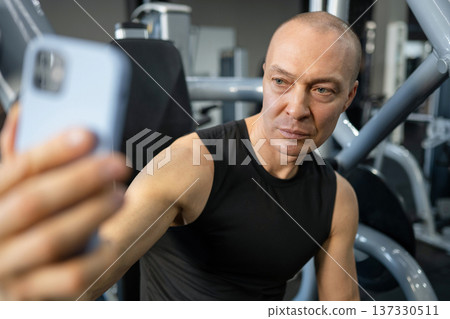 Fit man taking selfie in gym after training Fit man taking selfie in gym after training 137330511