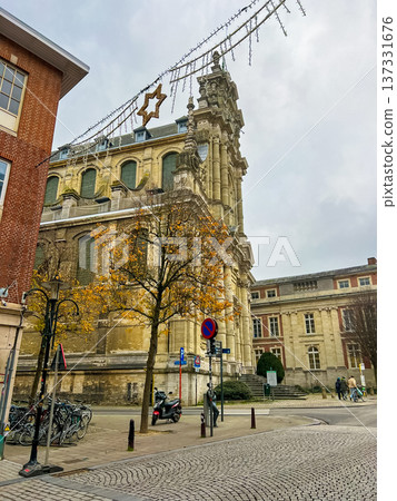 Victorian gothic church in Leuven with beige stone facade under blue sky 137331676