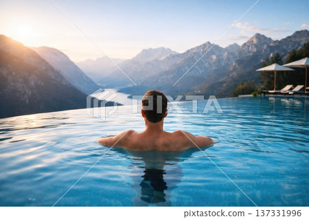 Man relaxing in infinity pool with breathtaking mountain and lake view symbolizing luxury travel and wellness Man relaxing in infinity pool with breathtaking mountain and lake view symbolizing luxury travel and wellness 137331996