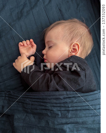 Peaceful sleeping baby on dark blue bedding Peaceful sleeping baby on dark blue bedding 137332093