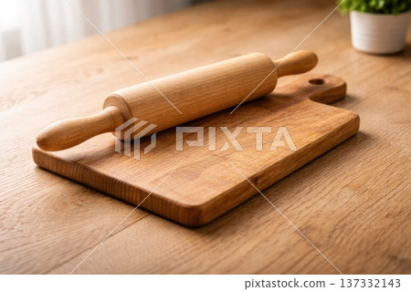 Wooden rolling pin on rustic cutting board in cozy kitchen interior Wooden rolling pin on rustic cutting board in cozy kitchen interior 137332143