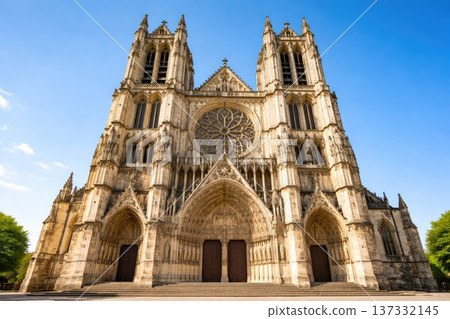 Majestic gothic cathedral facade with twin towers and rose window under blue sky Majestic gothic cathedral facade with twin towers and rose window under blue sky 137332145
