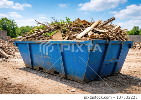 Construction waste wood debris in large blue industrial dumpster outdoors 137332225