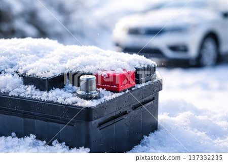 Car battery covered with snow in winter conditions with blurred vehicle in background Car battery covered with snow in winter conditions with blurred vehicle in background 137332235