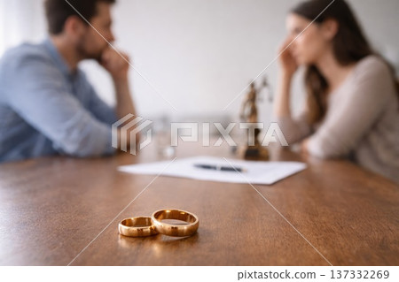 Unhappy couple with wedding rings on table discussing divorce or relationship problems Unhappy couple with wedding rings on table discussing divorce or relationship problems 137332269