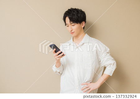 A young man looking at his smartphone A young man looking at his smartphone 137332924
