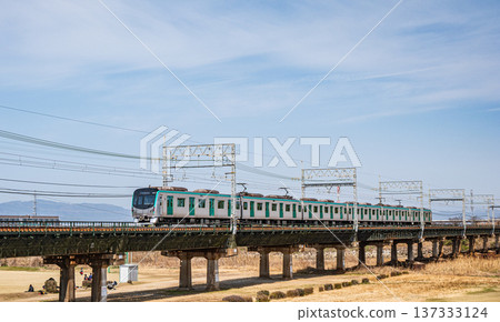 Kyoto Subway train crossing the Kintetsu Kyoto Line railway bridge over the Kizu River, Kyotanabe City, Kyoto Prefecture 137333124