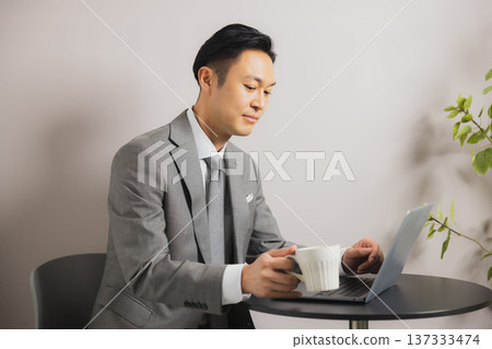 喝咖啡時看電腦的商人 137333474