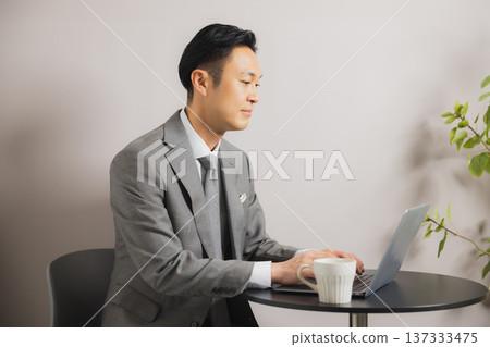 喝咖啡時看電腦的商人 137333475