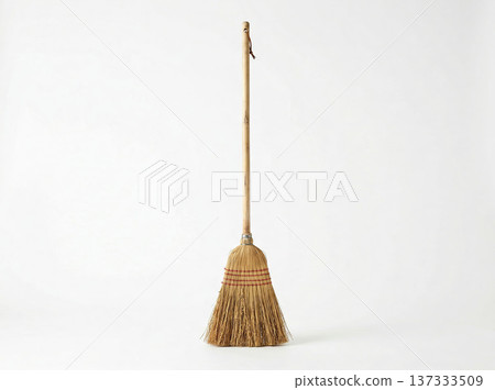 Traditional straw broom with wooden handle, standing upright on a clean white background. Traditional straw broom with wooden handle, standing upright on a clean white background. 137333509
