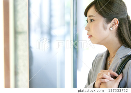 一位女商人正看著商店櫥窗。 137333732