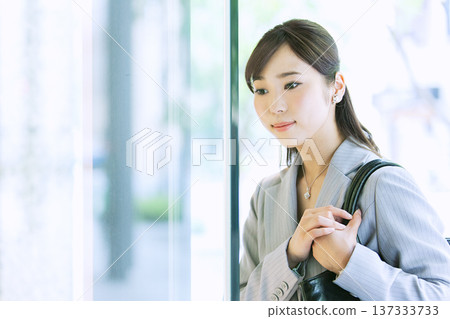 一位女商人正看著商店櫥窗。 137333733